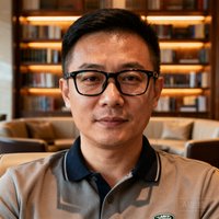 路虎揽胜车主陈先生的正面照，戴着黑框眼镜，休闲POLO衫打扮，身后是贵宾厅书架